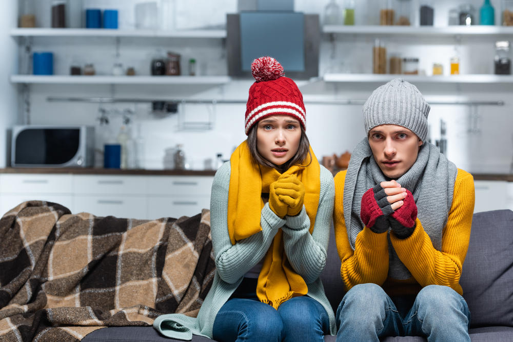 Two shivering in a cold house because of a broken furnace